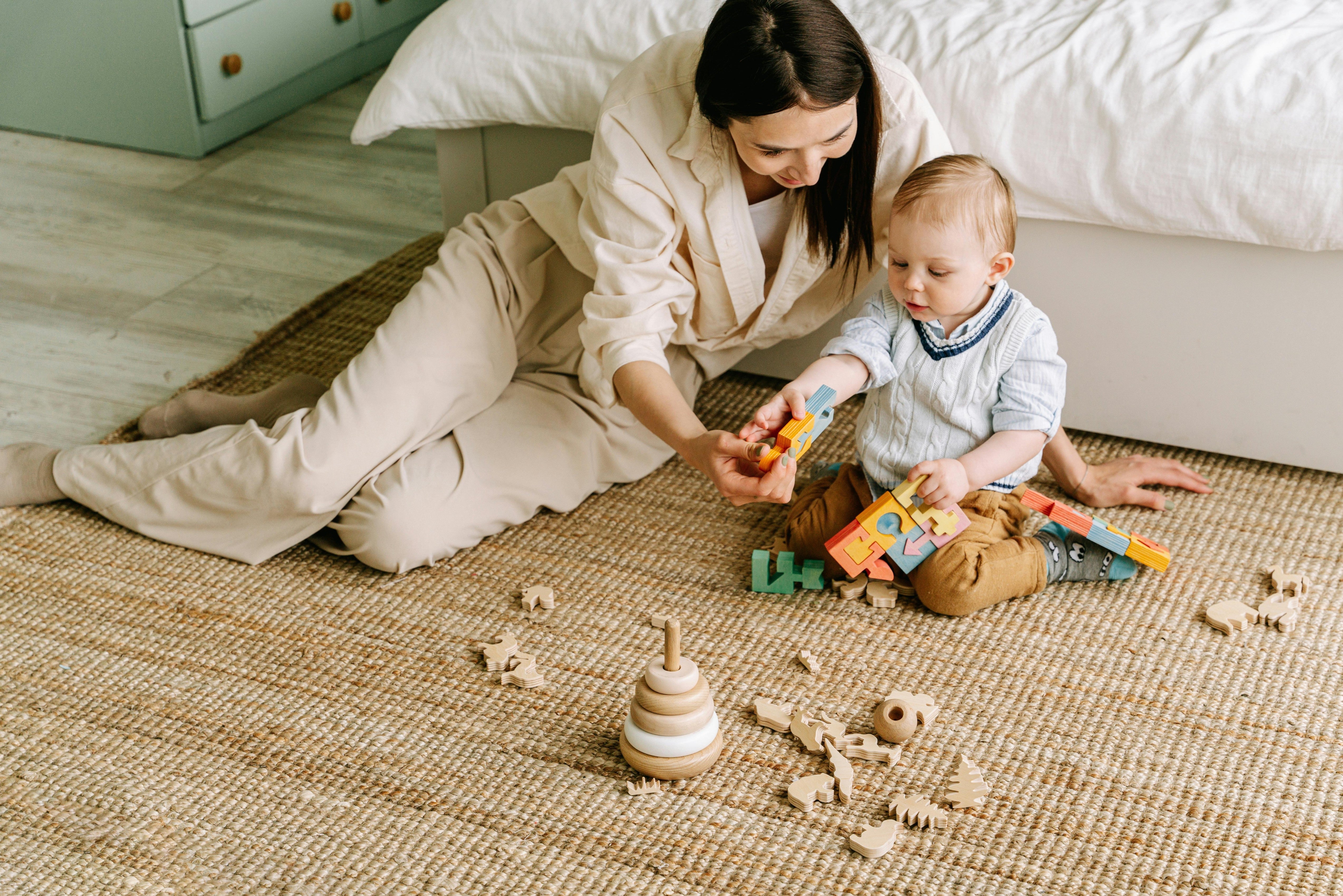 Mother and toddler playing with colorful wooden blocks and toys highlighting creative playtime products