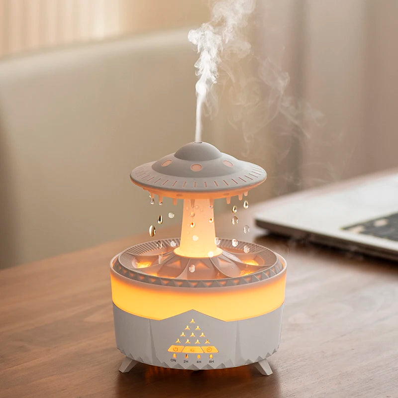 Rotating water droplet essential oil humidifier emitting mist and glowing warm yellow light on wooden table
