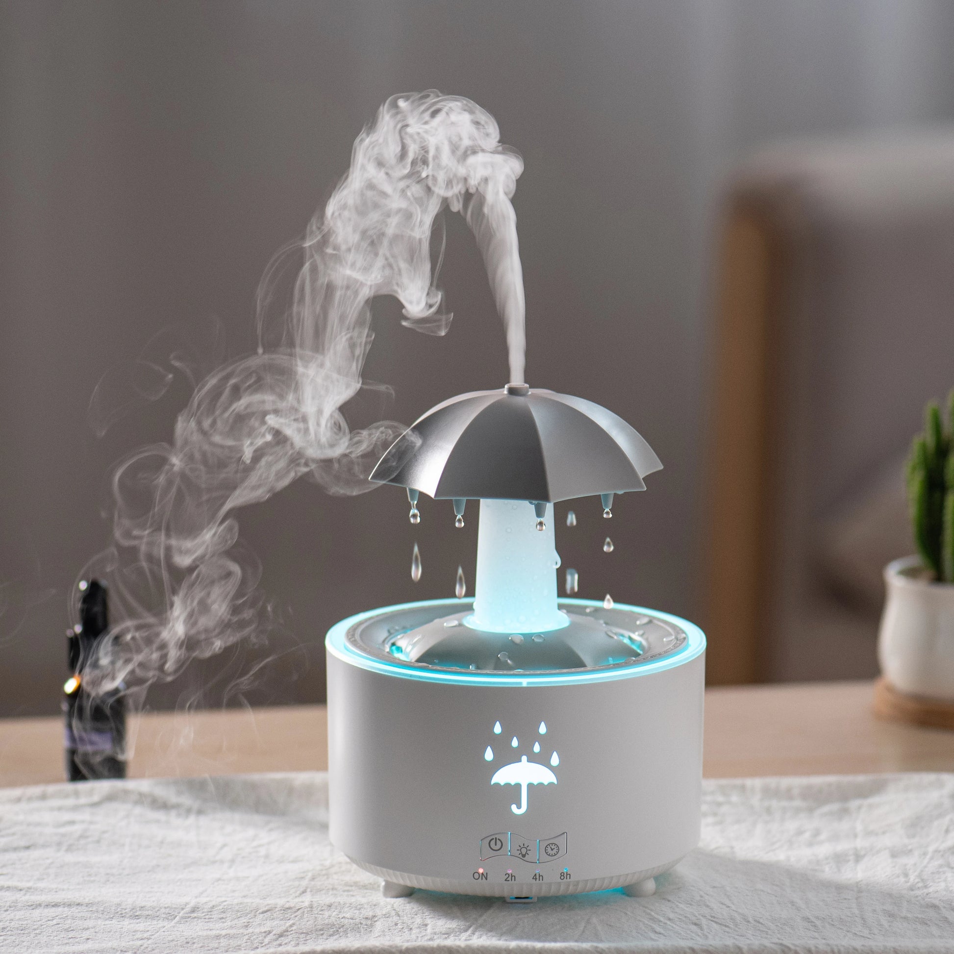 Rotating water droplet essential oil humidifier with umbrella design and mist emitted on a table